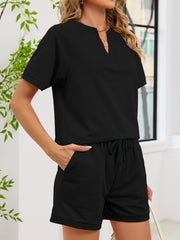 Black loungewear shorts with drawstring waist and cuffed hem, paired with a short-sleeve split-neck top.