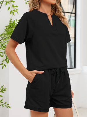 Black loungewear shorts with drawstring waist and cuffed hem, paired with a short-sleeve split-neck top.