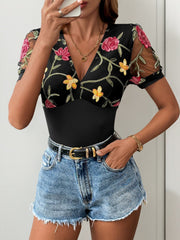 Black bodysuit with embroidered floral mesh sleeves and V-neck.