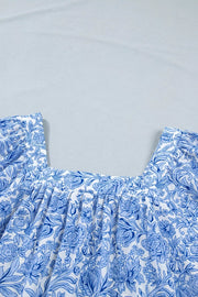 Floral pleated blouse with square neckline in blue and white floral print polyester.