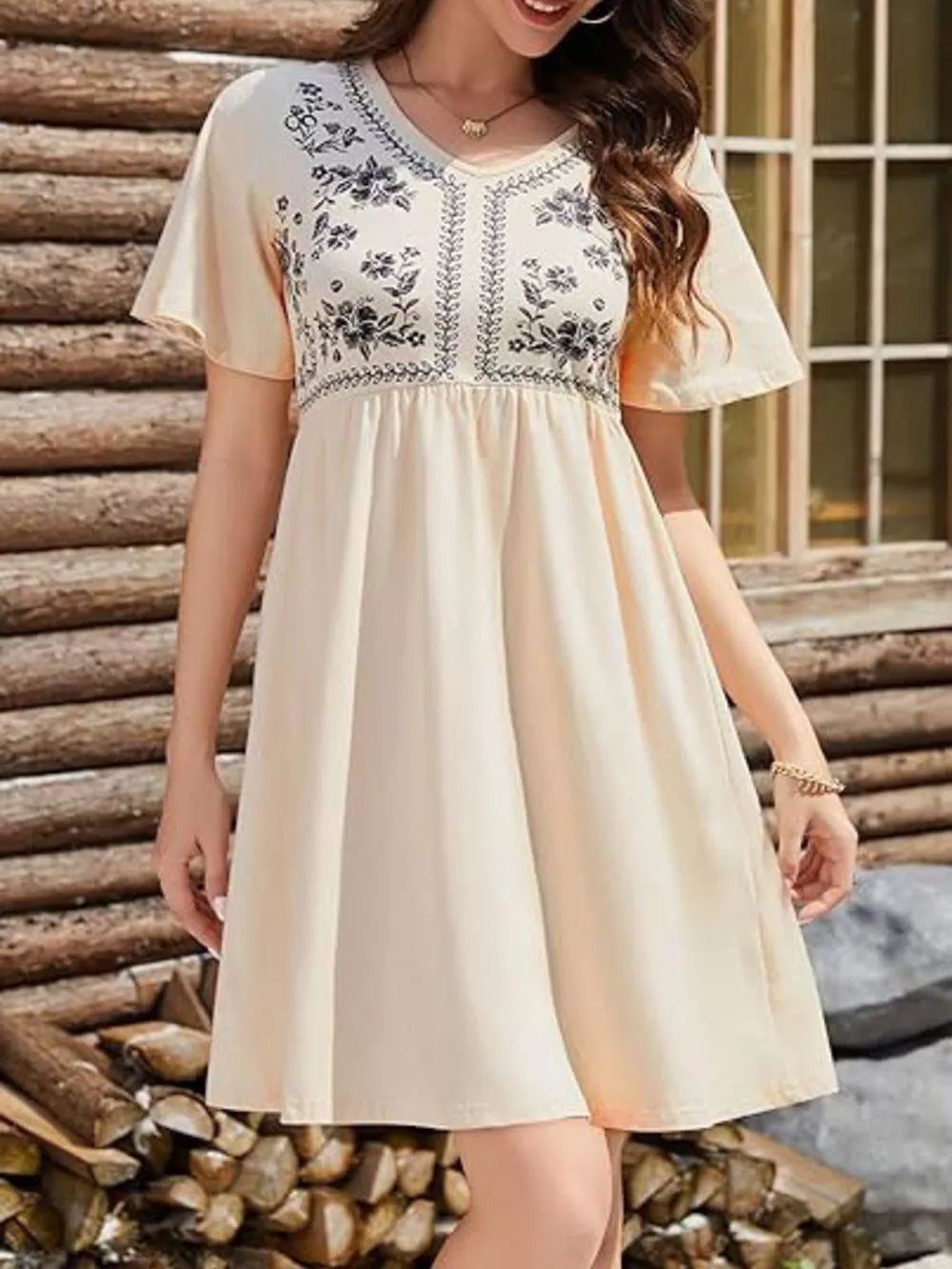 Embroidered floral v-neck mini dress in light yellow with short flutter sleeves and a gathered waist.