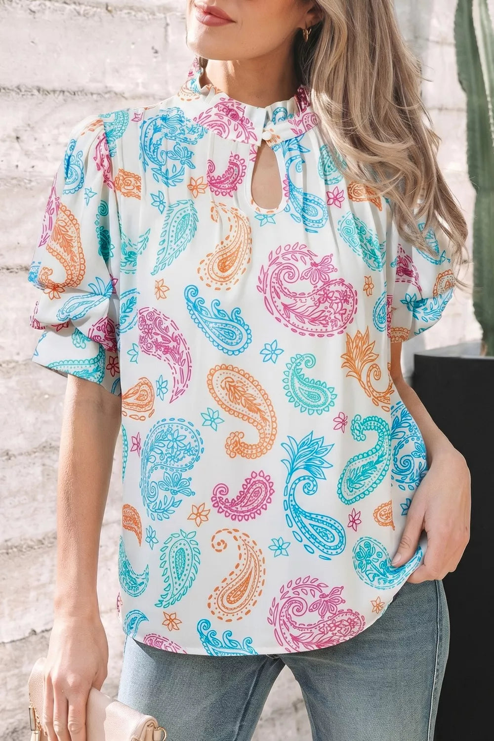 Maternity blouse with vibrant paisley print, puff sleeves, and keyhole neckline.