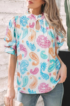 Maternity blouse with vibrant paisley print, puff sleeves, and keyhole neckline.