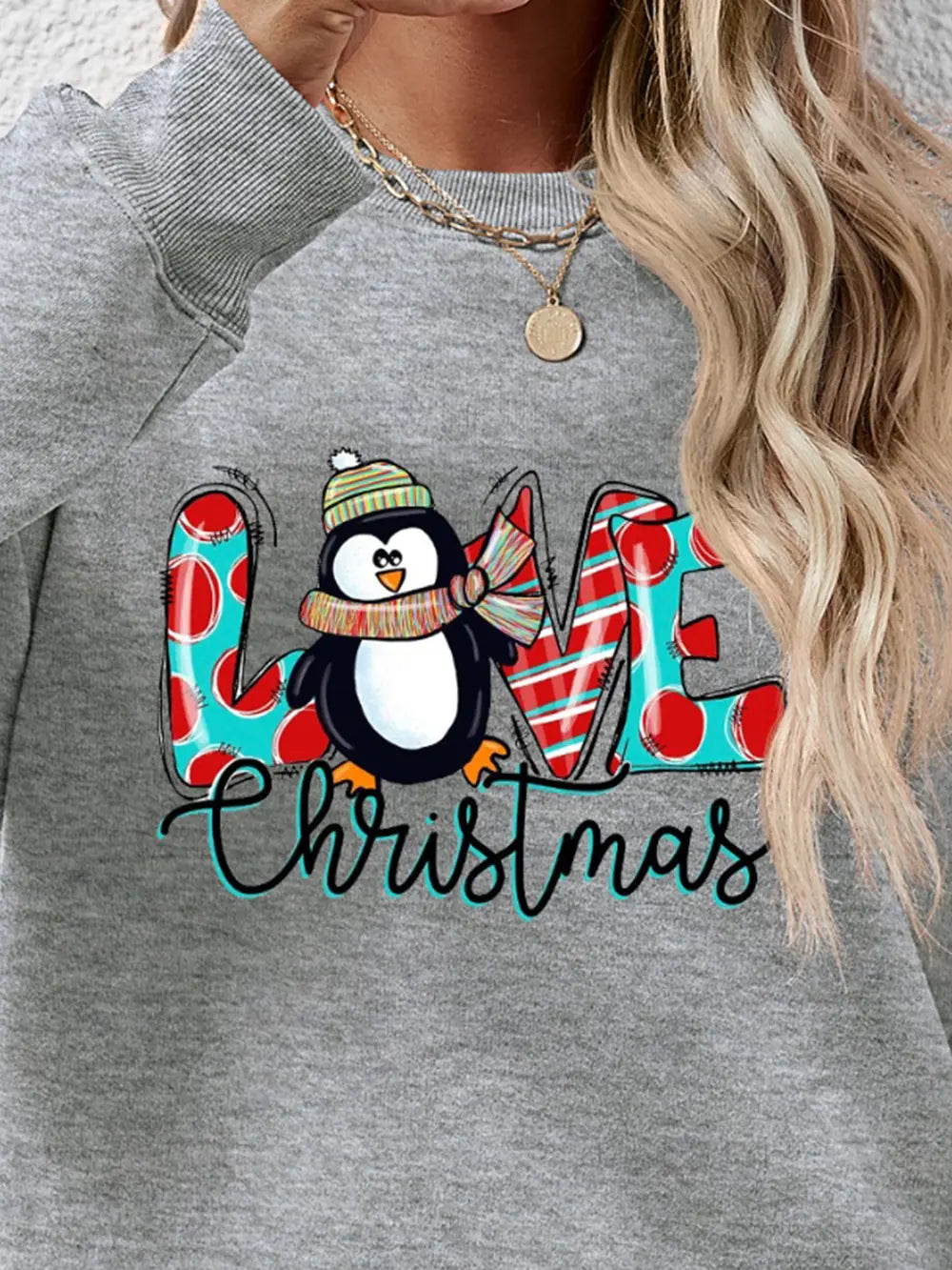 Grey sweatshirt with festive penguin graphic and Christmas text, red polka dots, red and white stripes.