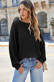 Black waffle knit raglan top with lace yoke detail and crew neck.
