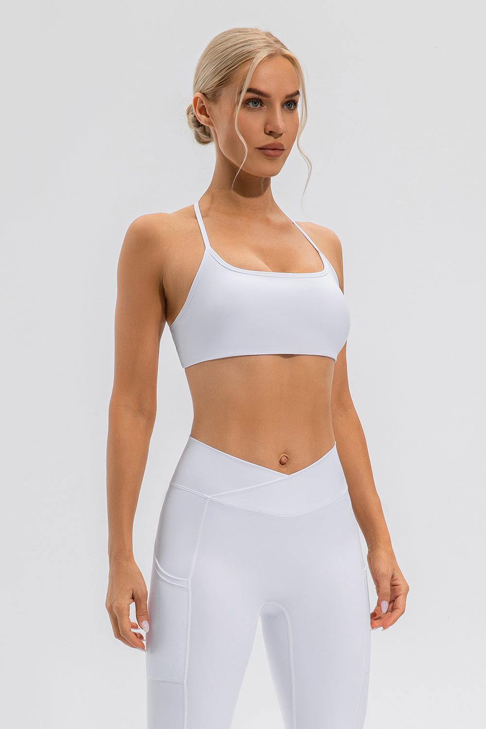White crisscross back sports bra with a square neckline and thin straps.