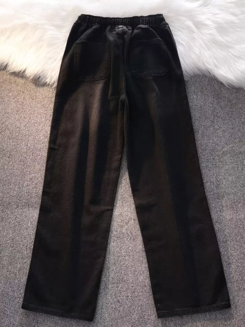 Black vintage wash wide-leg jeans with drawstring waist and back pockets.