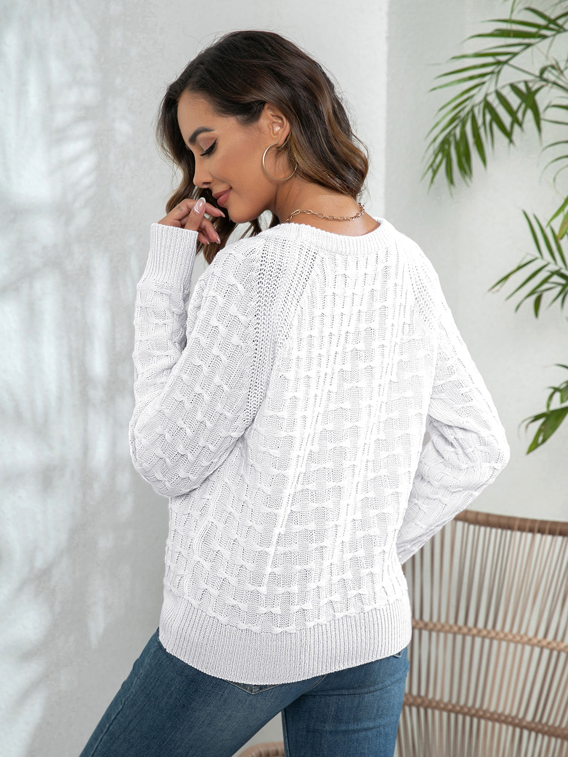 White crewneck knit sweater with textured pattern and button details.