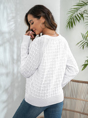 White crewneck knit sweater with textured pattern and button details.