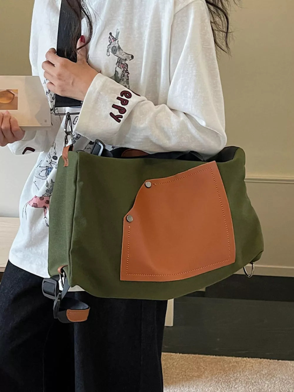 Green nylon crossbody bag with contrast tan pocket and silver hardware.