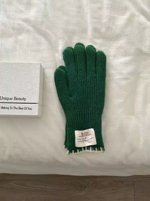 Dark green ribbed knit gloves with scalloped cuff detail and white trim.