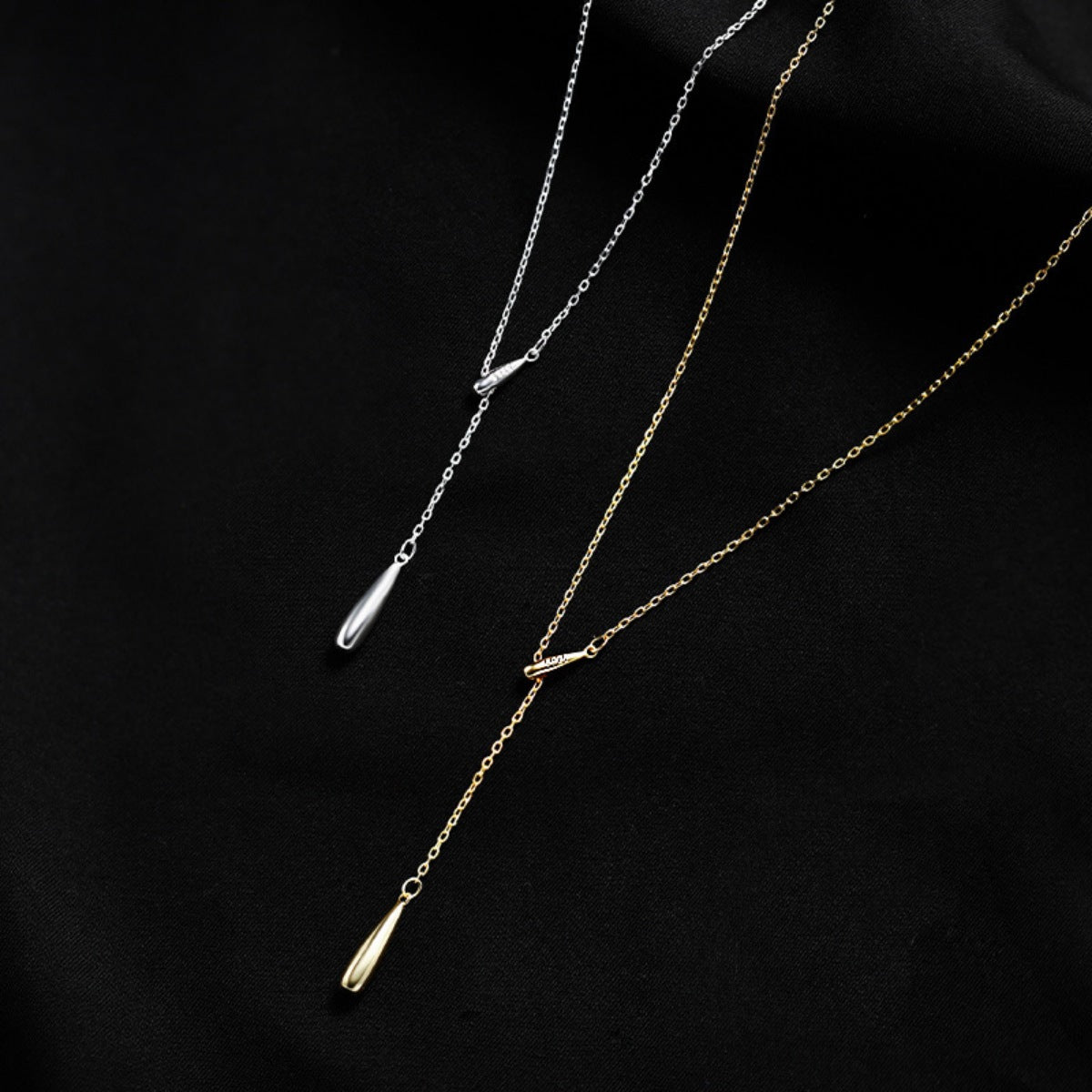 Y-shaped pendant necklace in gold and silver with teardrop charms.