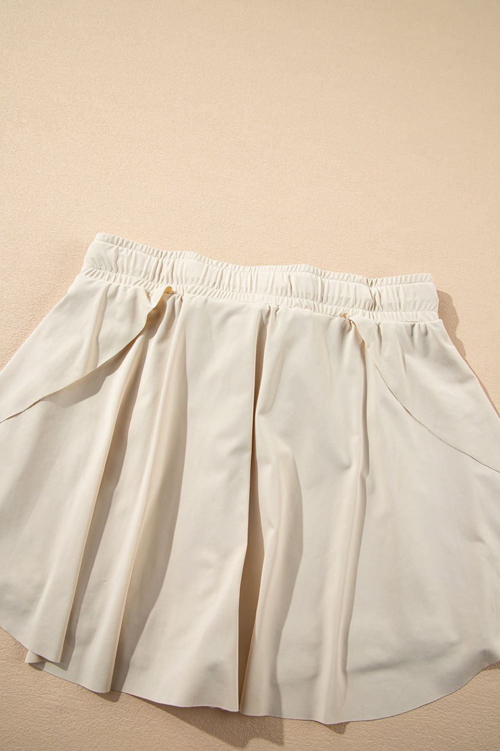 Beige ruffled skort with elastic waist and tie detail