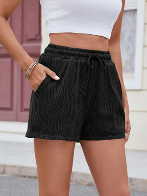 Black textured wave drawstring shorts with pockets and a cinched waist.