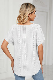 White eyelet tie-neck blouse with flutter sleeves and a relaxed fit.