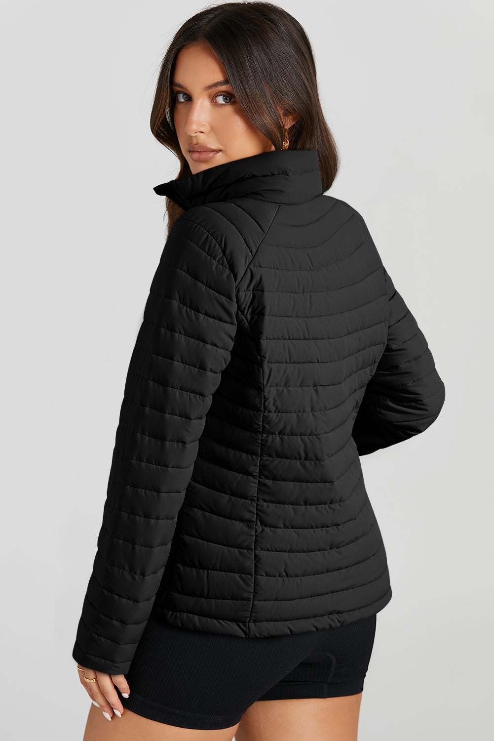 Black quilted stand collar puffer jacket with horizontal quilting detail.
