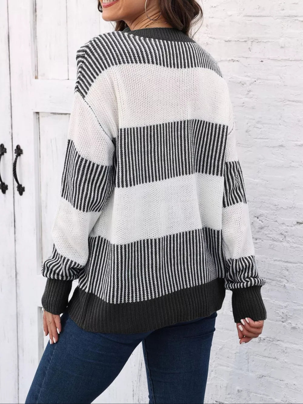 Cozy knit sweater with black and white stripes and a dark grey hem and cuffs.