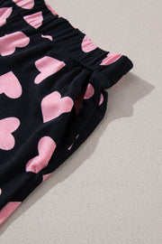 Black lounge set pants with pink heart print and elastic waistband with pockets.