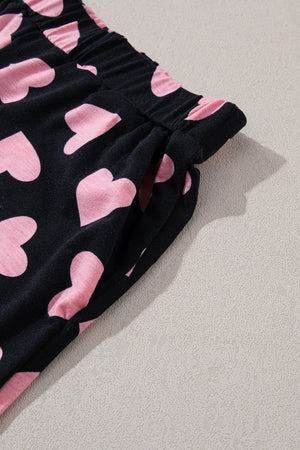Black lounge set pants with pink heart print and elastic waistband with pockets.