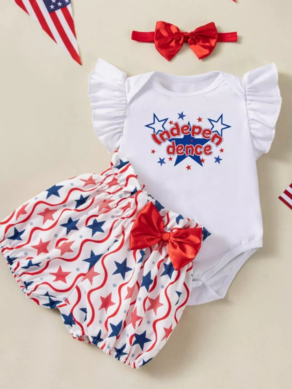 Baby 3-piece outfit with white Independence graphic bodysuit, star print bloomers, and red bow headband.