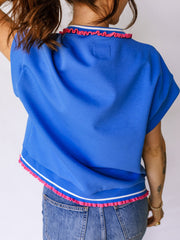 Blue polo shirt with ruffled collar and hem details