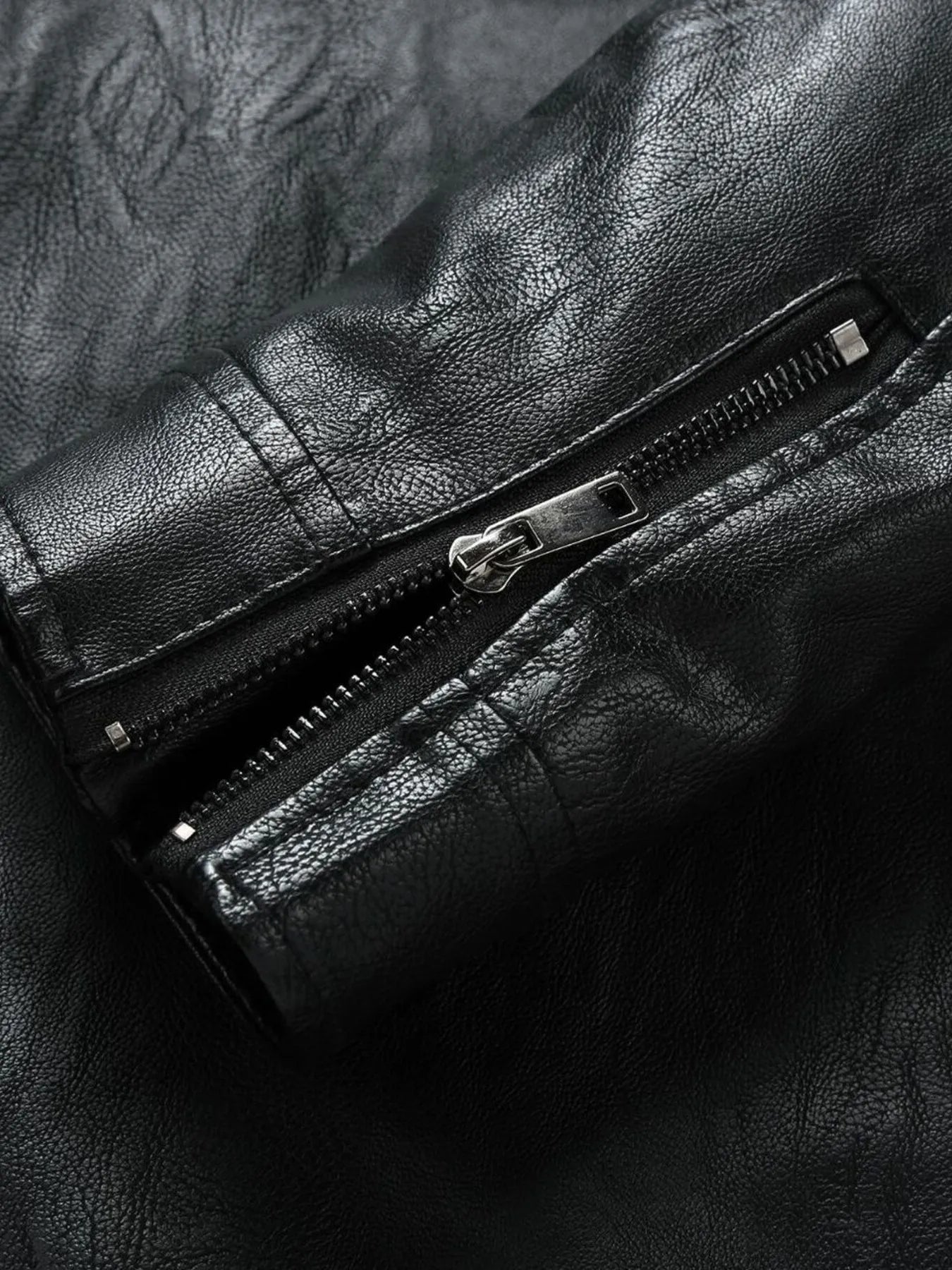 Black plus-size moto jacket with zip detail and textured faux leather.