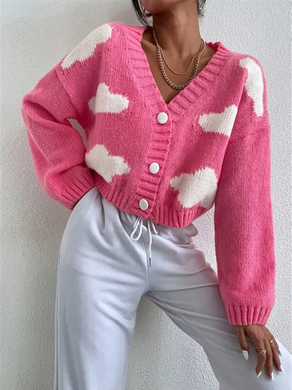 Hot pink acrylic button cardigan with white cloud pattern, V-neck, long sleeves.