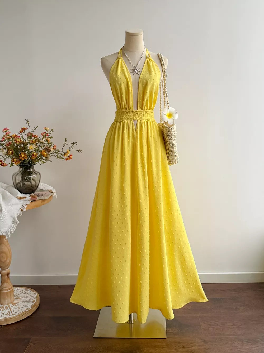 Yellow Swiss dot halter maxi dress with smocked waist and deep V-neck.
