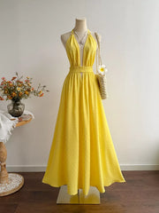 Yellow Swiss dot halter maxi dress with smocked waist and deep V-neck.