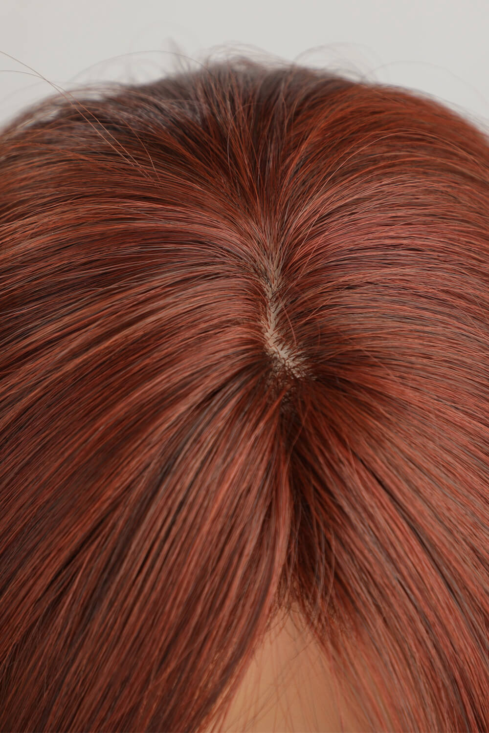 Layered copper red synthetic wig showing natural-looking scalp detail