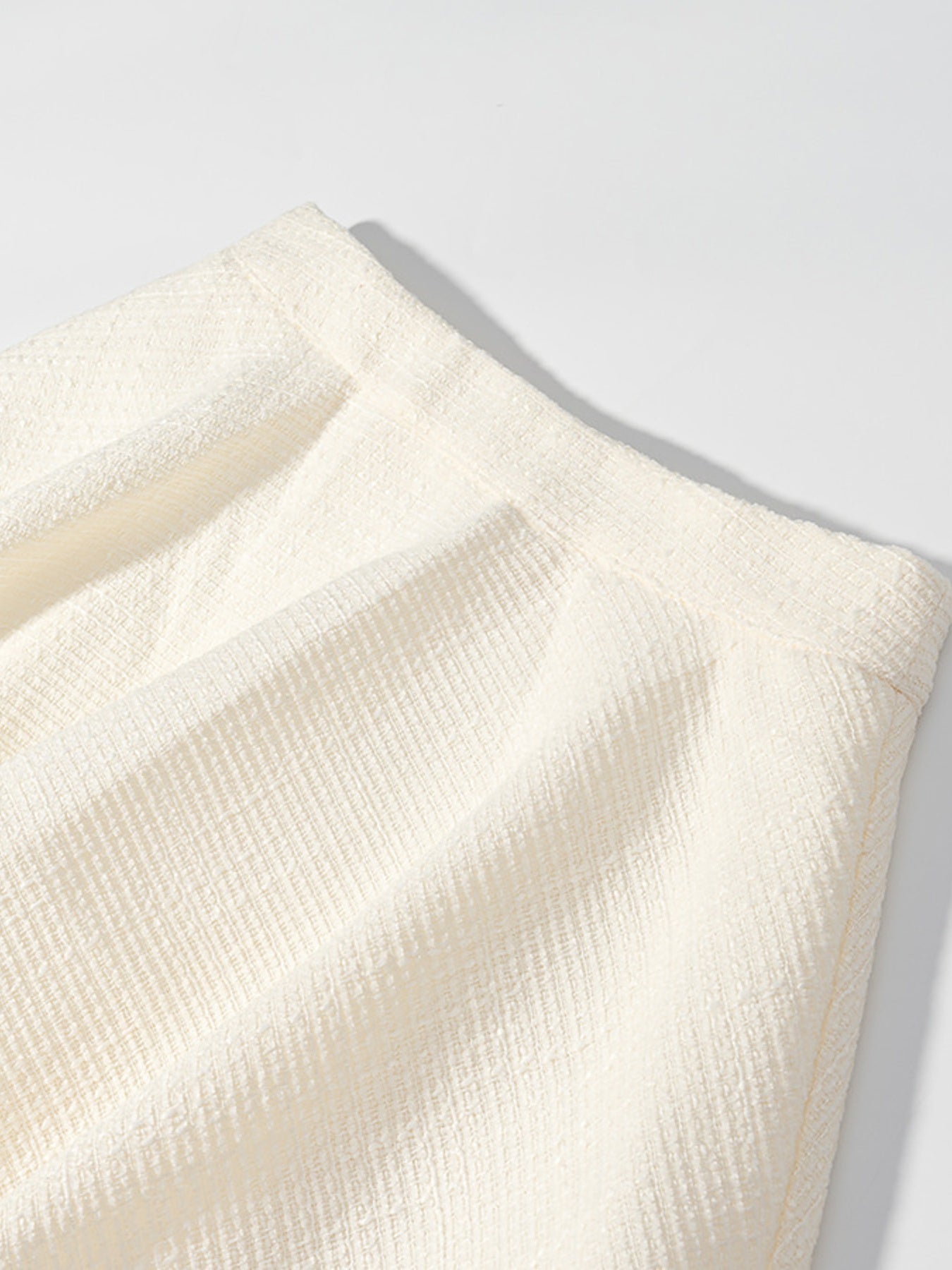 Textured cream two-piece set with buttoned top, showing fabric detail