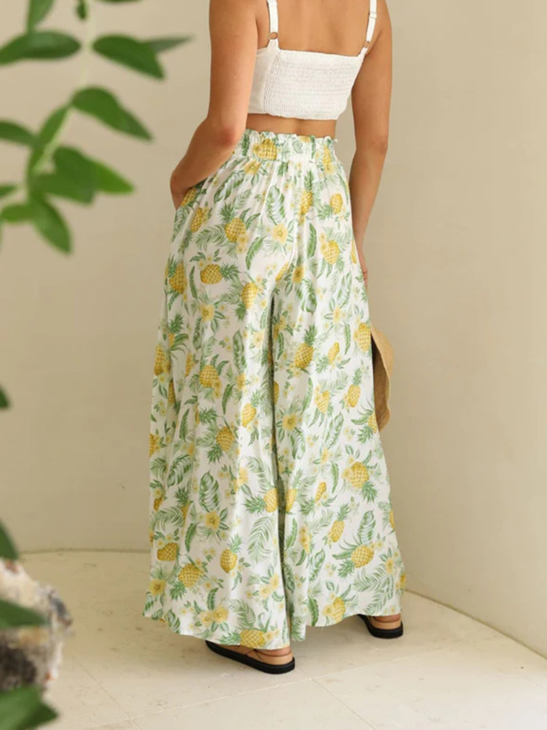 Pineapple print palazzo trousers in white with yellow pineapples and green leaves, featuring a high elastic waist and wide