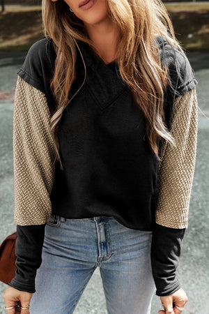 Black and tan colorblock hoodie with textured sleeves and v-neck.
