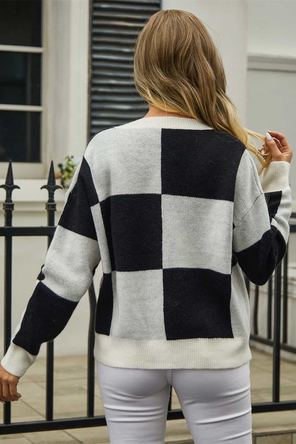 Colorblock geometric knit cardigan in black and white acrylic with buttoned front.