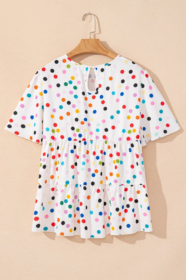 White tiered blouse with rainbow polka dots and flutter sleeves.