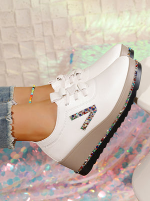 White wedge sneakers with colorful rhinestone embellishments on the side and sole.