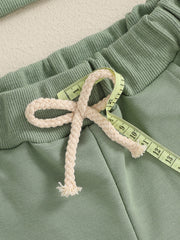 Green cotton baby outfit with drawstring waist and ribbed waistband detail.