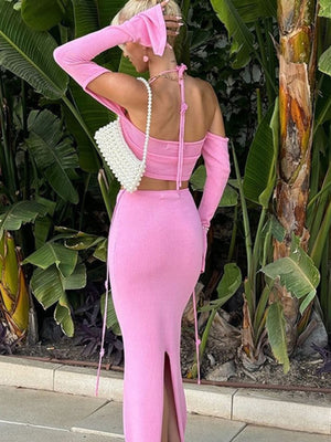 Pink halter neck two-piece knit set with long sleeves and a side slit skirt.