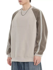 Oversized raglan sleeve sweatshirt in gray apricot with decorative zigzag trim on sleeves.