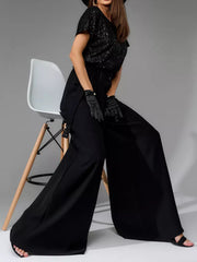 Black sequin bodice and wide-leg palazzo pants ensemble with black gloves.