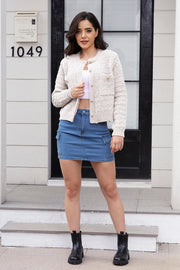 Textured bouclé knit bolero jacket in white with gold buttons and pocket details.