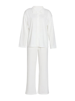 White ribbed knit loungewear set with buttoned collared shirt and relaxed fit pants.