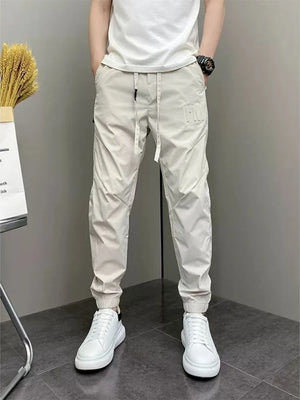 Men's beige cotton drawstring sweatpants with a subtle logo detail.