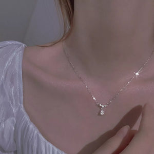 Elegant silver necklace with a teardrop zircon pendant, sparkling on a woman's neck.