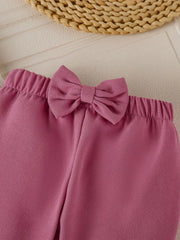 Baby girl's flare pants in Moonlit Mauve with a decorative bow detail on the waistband.