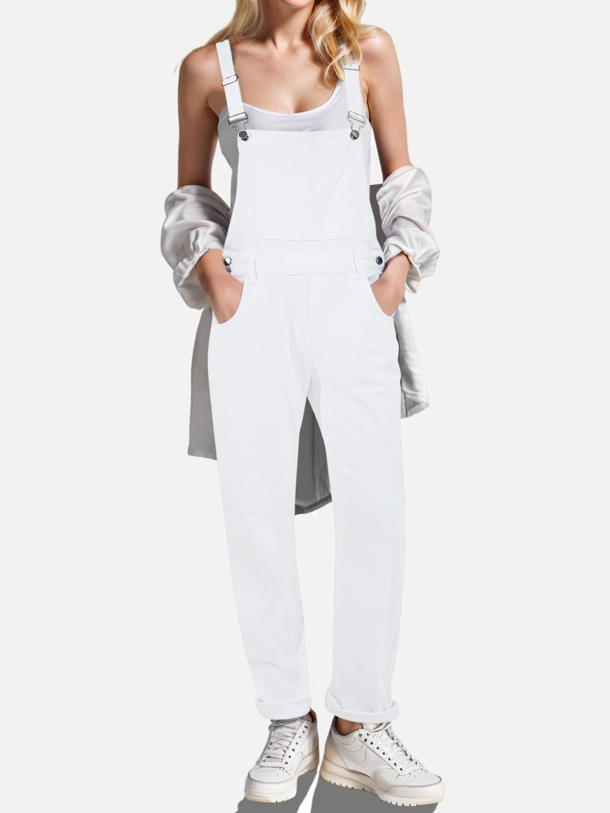 White denim overalls with relaxed fit, button sides, and crisscross straps.