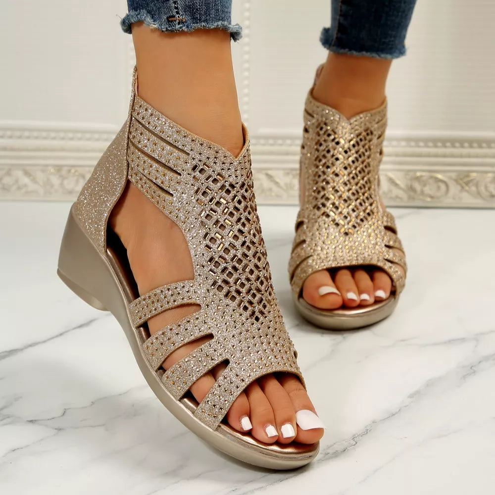 Gold cutout ankle cuff wedge sandals with rhinestone embellishments and a zipper closure.