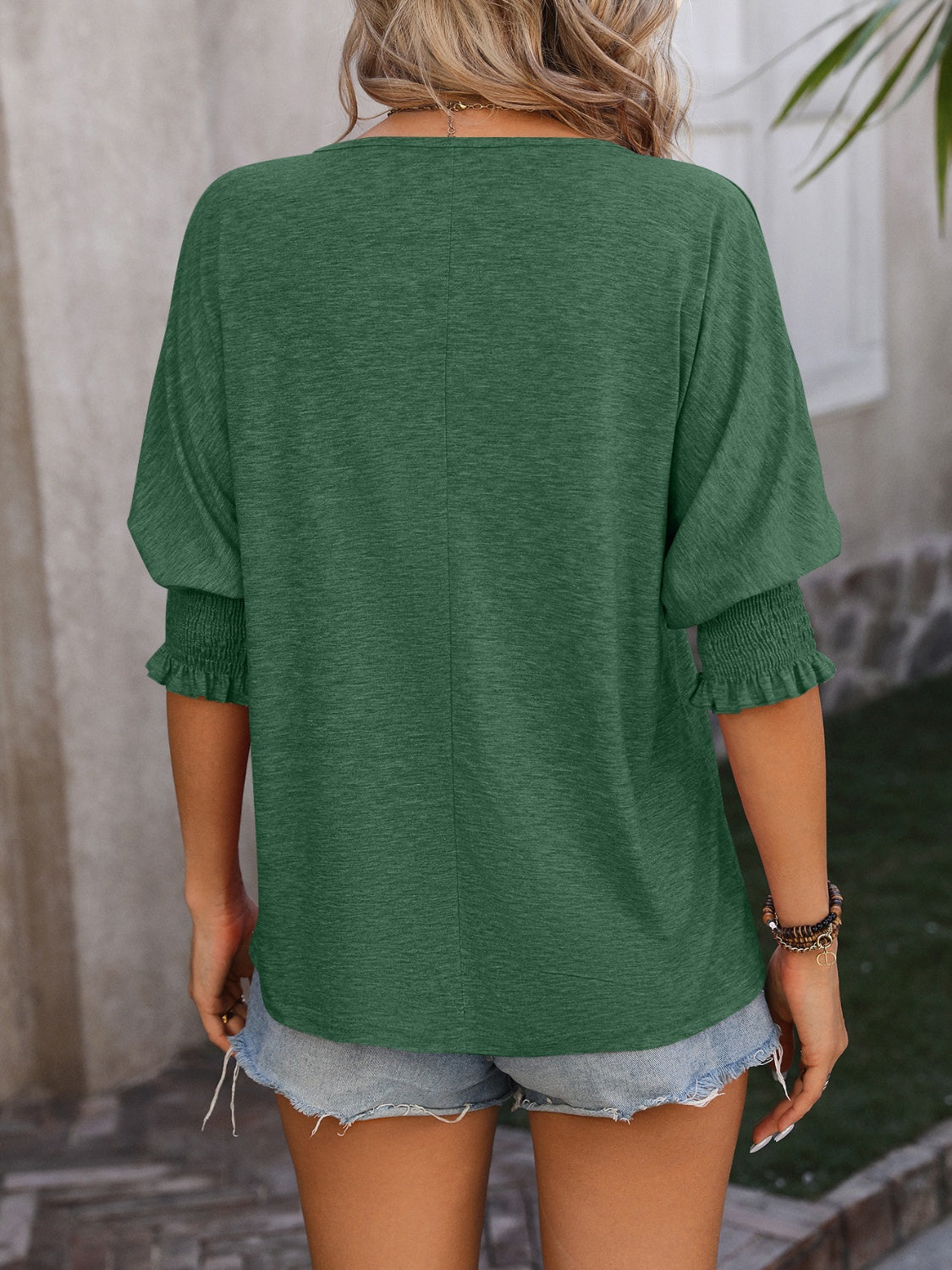 Dark green blouse with shirred sleeve cuffs and a keyhole neckline detail.