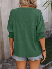 Dark green blouse with shirred sleeve cuffs and a keyhole neckline detail.