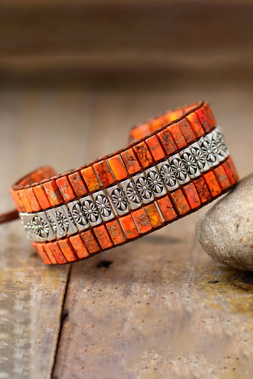 Orange beaded bracelet with floral silver accents, boho style